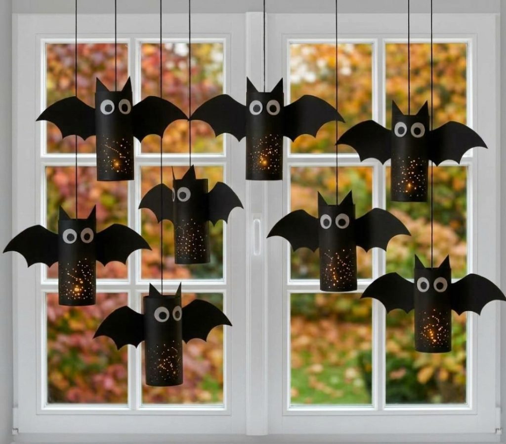 leuchtende schwarze BENBINO Papier-Fledermäuse aufgereiht mit Minikürbissen auf weißem Grund für den Blog-Header.