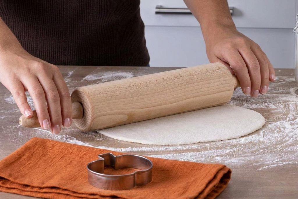 Pizzateig wird auf der Arbeitsfläche für BENBINO Halloween-Pizzas ausgerollt